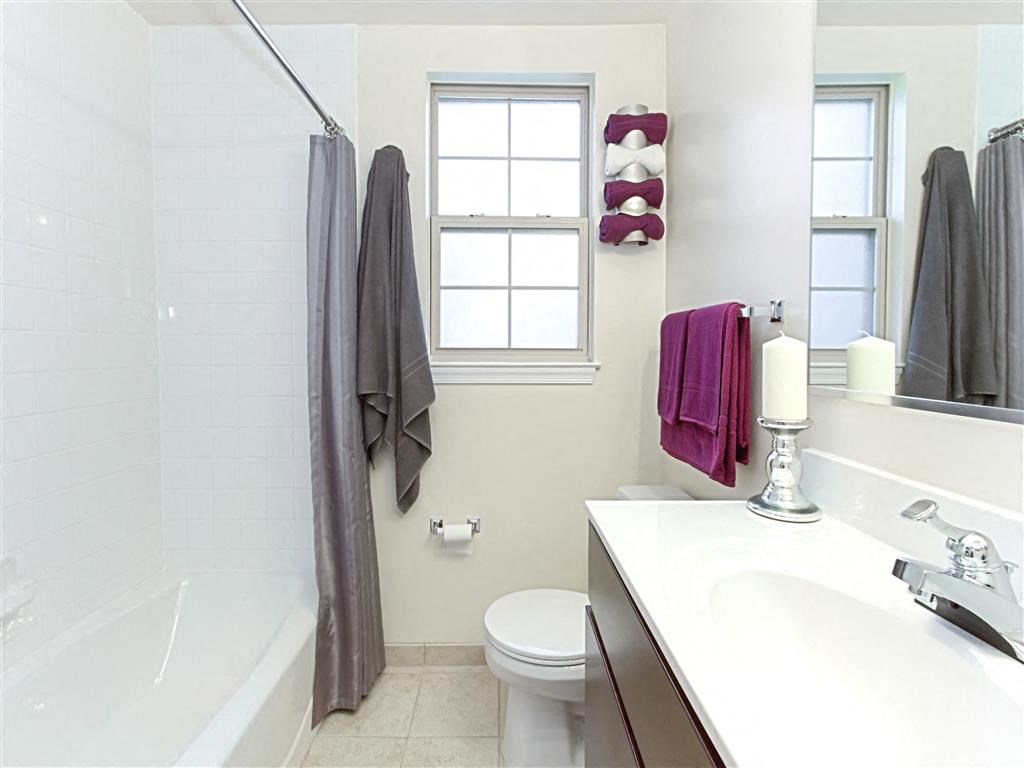bathroom with tub, vanity, toilet and window at fairway park apartments in washington dc
