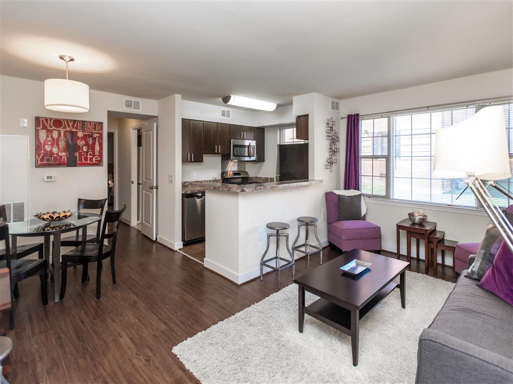 living area with sofa, coffee table large windows and views of dining area and kitchen at fairway park apartments in washington dc