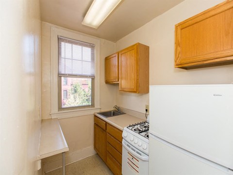 kitchen with refrigerator, gas range, breakfast bar and window at the foreland apartments in capitol hill washington dc