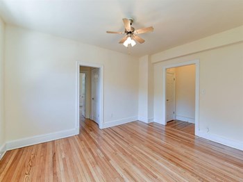 vacant bedroom with hardwood flooring and ceiling fan at the klingle apartments in washignton dc - Photo Gallery 17