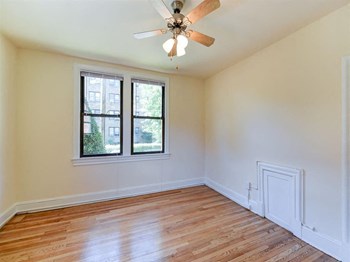 vacant bedroom with hardwood floorings, large windows and ceiling fan at the klingle apartments in washignton dc - Photo Gallery 18