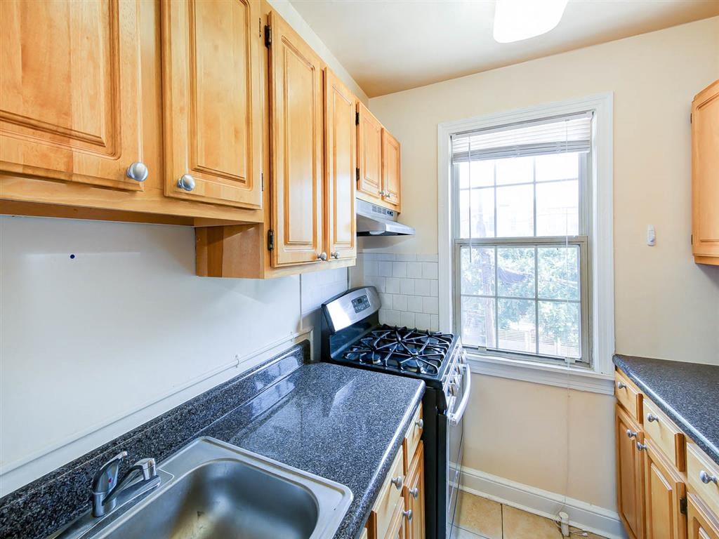 kitchen with gas range, oak cabinetry and window at the meridian park apartments in columbia heights washington dc