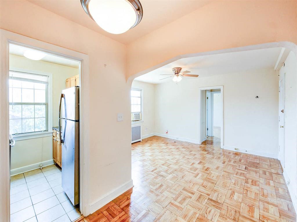 vacant living area with hardwood floors, ceiling fan and view of kitchen at the meridian park apartments in columbia heights washington dc