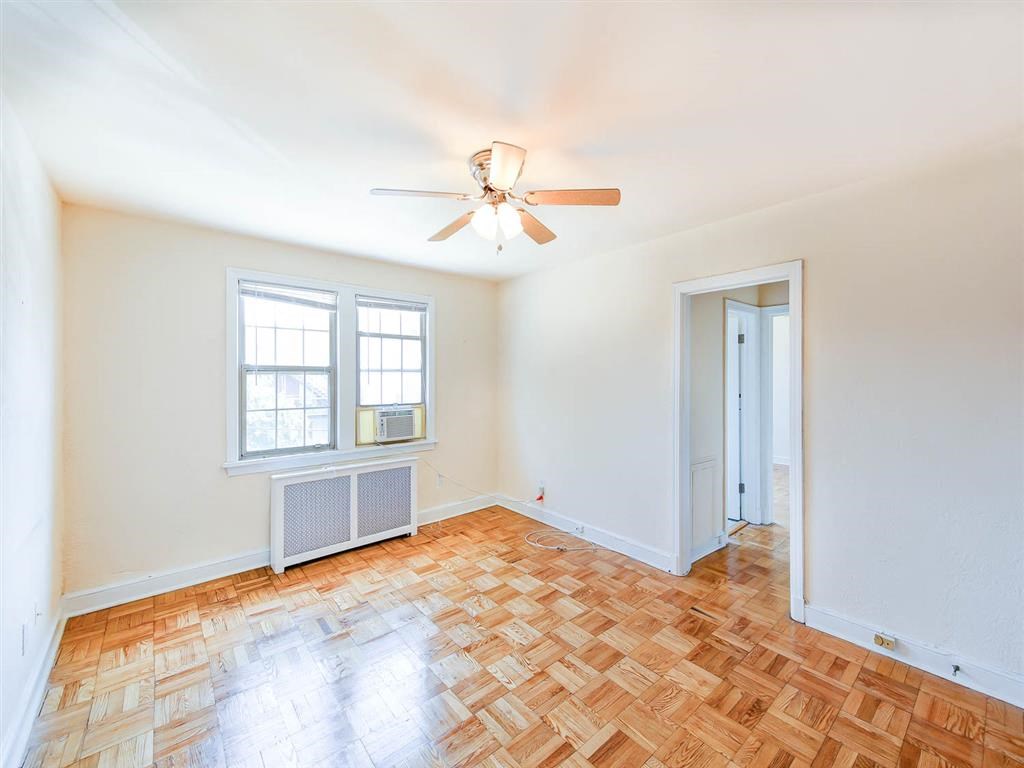 vacant living area with hardwood floors, ceiling fan and window at the meridian park apartments in columbia heights washington dc