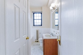 bathroom with vanity, tub, toilet, large mirror and window at the dahlia apartments in Washington dc - Photo Gallery 28