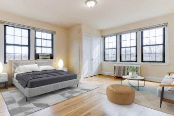 studio bedroom area with bed, nightstands, large windows and view of living area at the dahlia apartments in washington dc