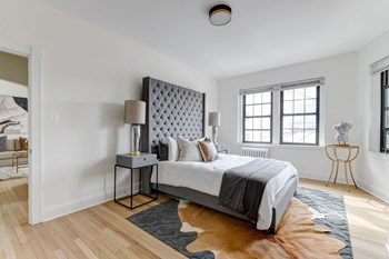 bedroom with bed, nightstand, large windows and hard wood floors at the dahlia apartments in washington dc - Photo Gallery 12