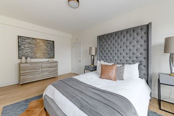 bedroom with bed, night stands, dresser and hardwood floors at the dahlia apartments in washington dc - Photo Gallery 13