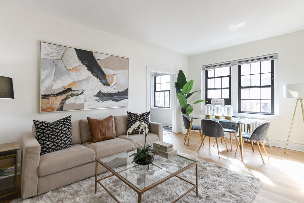living area with large windows, sofa, coffee table, hardwood floors and view of dining area at the dahlia apartments in washington dc