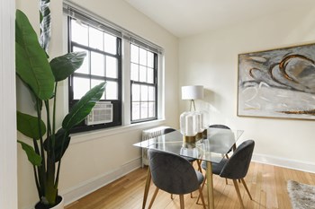 dining area with table chairs, houseplants, modern artwork and hardwood flooring at the dahlia apartments in washington dc - Photo Gallery 6