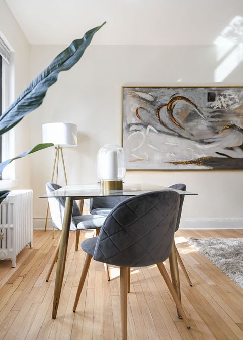 dining area with table chairs, houseplants, modern artwork and hardwood flooring at the dahlia apartments in washington dc