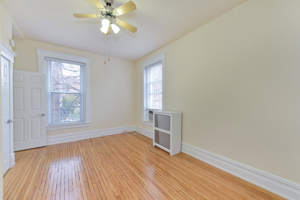 vacant bedroom with hardwood floors, large windows and ceiling fan at dupont apartments in washington dc