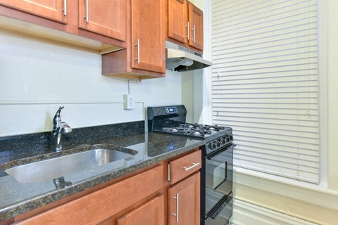 a kitchen with a sink and stove and a window