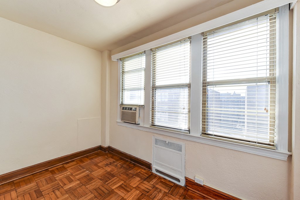 vacant bedroom with hardwood flooring, lighting and large windows at eddystone apartments in washington dc