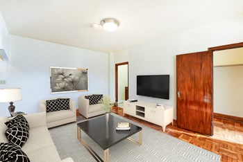 living area with sofa, coffee table, hardwood floors and view of bedroom at eddystone apartments in washington dc - Photo Gallery 6