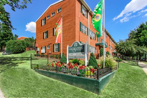 A red brick building with a green lawn in front.
