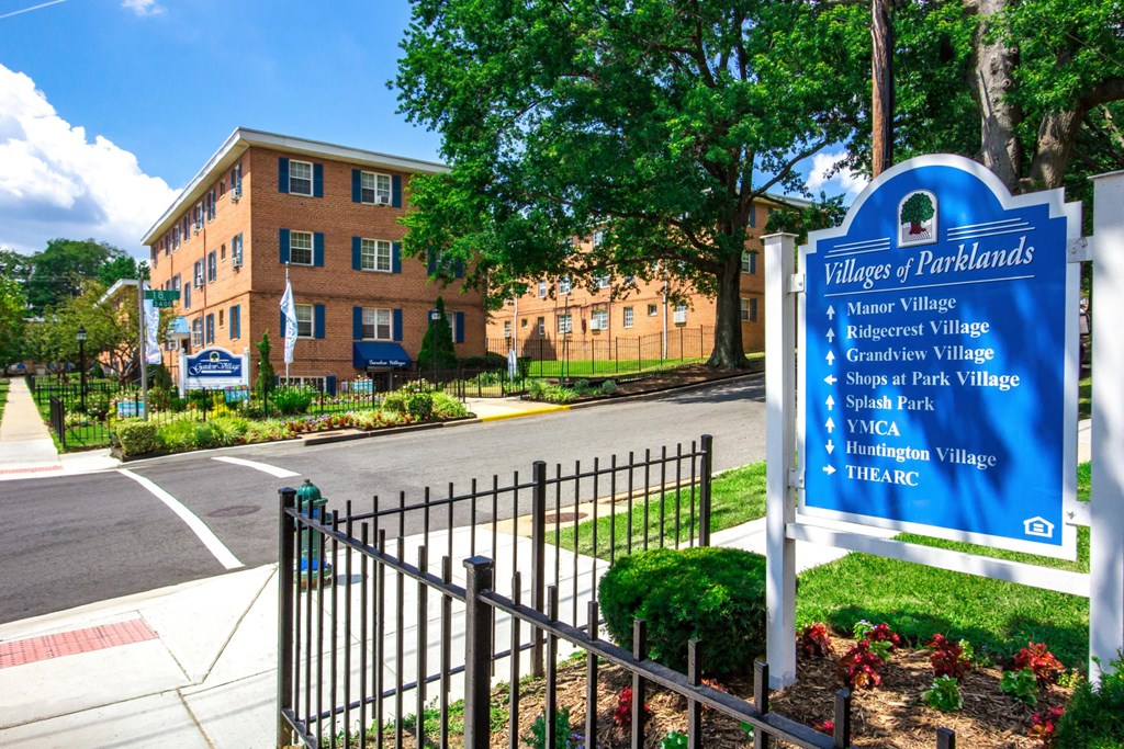 A sign in front of a building that says Villages of Parklands.