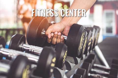 A person is lifting a dumbbell in a fitness center.