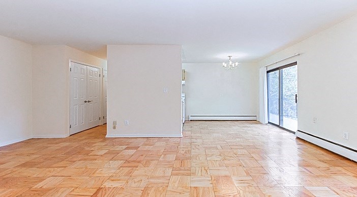 open layout of apartment showing living and dining areas with door leading to balcony at fort totten apartments in washington dc