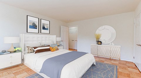 a white bedroom with a bed and a mirror