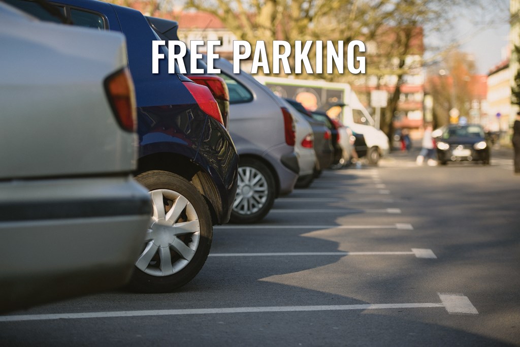 A line of cars parked in a parking lot with the words "FREE PARKING" overlaid on the image.