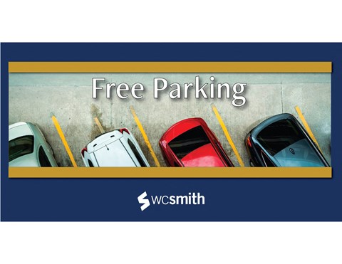 free parking sign with several cars parked in a parking lot