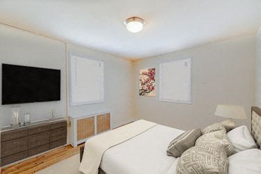 bedroom with bed, nightstands, and tv at garden village tax credit apartments in congress heights washington dc