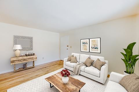 a living room with a white couch and a wooden coffee table at garden village apartments in congress heights washington dc