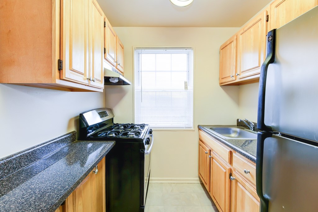 A kitchen with wooden cabinets and black appliances.