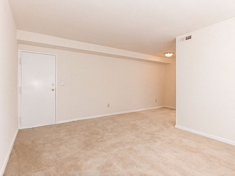 an empty living room with a door to a closet