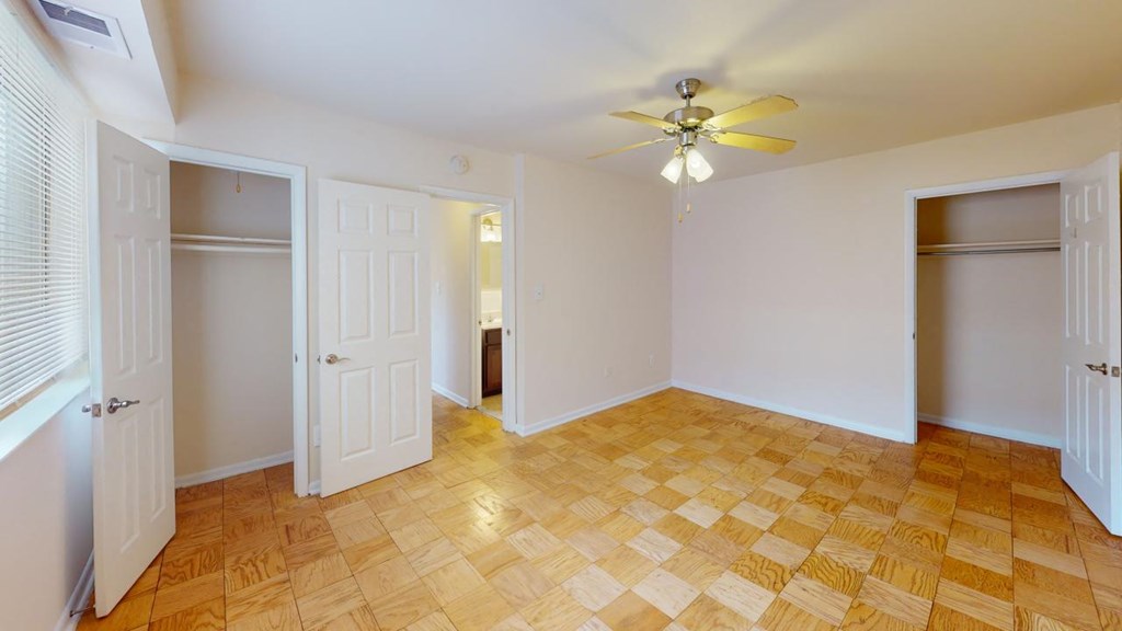 a bedroom with a ceiling fan and a closet