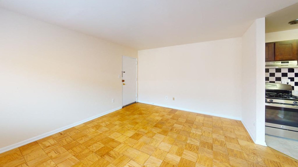 a living room with a wood floor and a kitchen