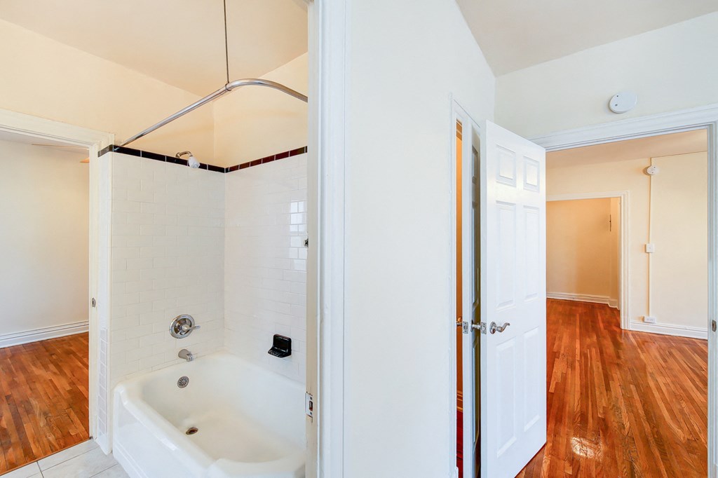 bathroom with tub and views of bedroom and living areas at hampton courts apartments in washington dc