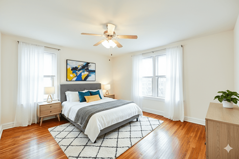 A bedroom with a bed, nightstands, and a ceiling fan.