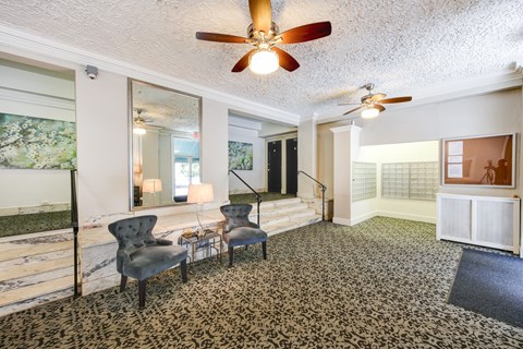 a living room with two chairs and a ceiling fan