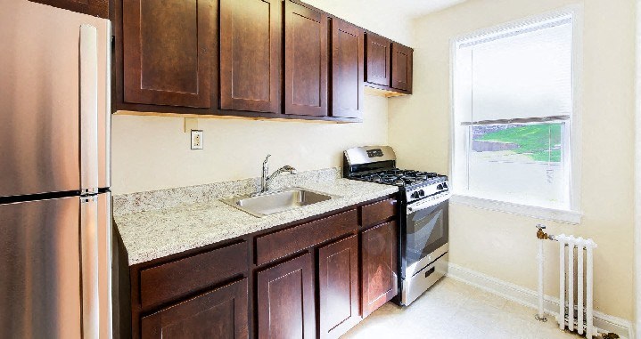 kitchen with wood cabinetry, gas range, and stainless steel appliances at hillside terrace apartments in washington dc
