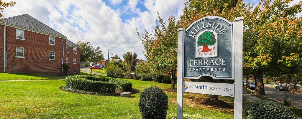 exterior of brick apartment building and monument sign at hillside terrace apartments in washington dc
