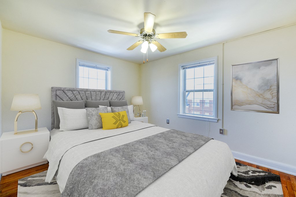 Bedroom with bed, nightstands, windows and ceiling fan  at hillside terrace apartments in washington dc