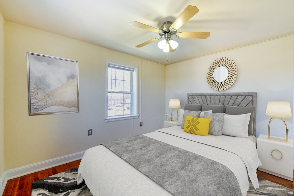 Bedroom with bed, nightstands, large windows, and ceiling fan  at hillside terrace apartments in washington dc