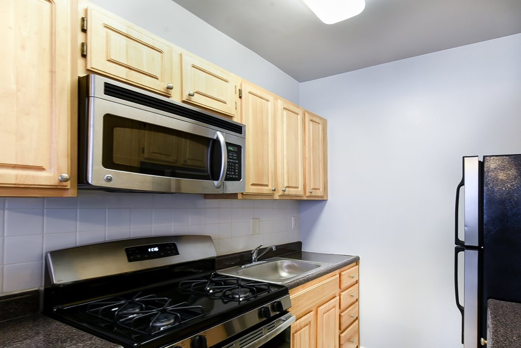 A kitchen with wooden cabinets and a black stove top.
