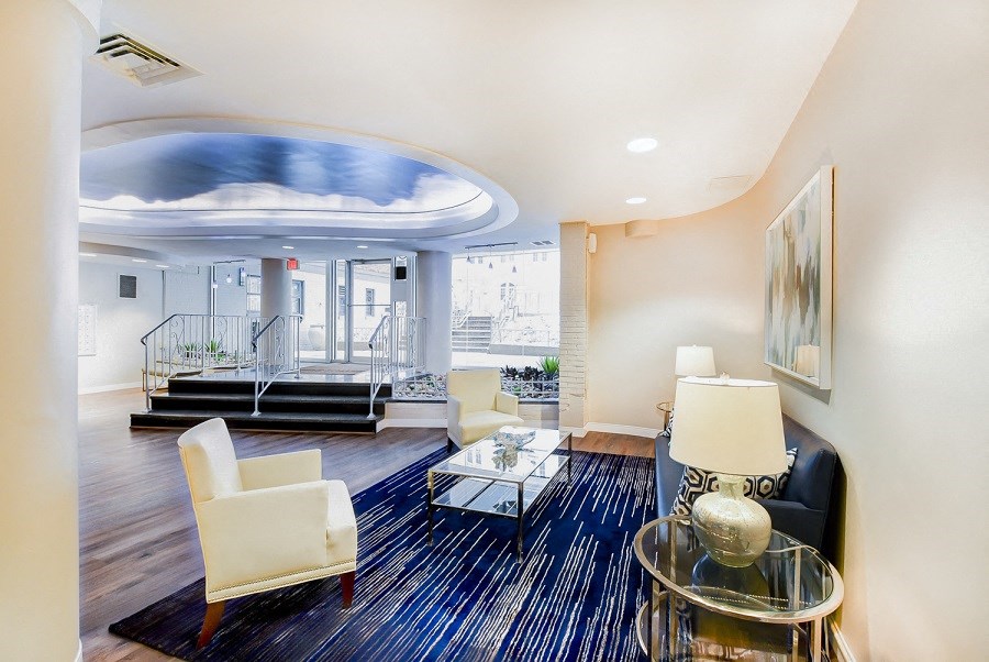 front entrance lobby lounge with social seating, view of front entrance and modern artwork  at hilltop house apartments in columbia heights washington dc