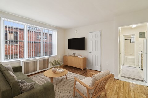 A living room with a couch, chair, and television.