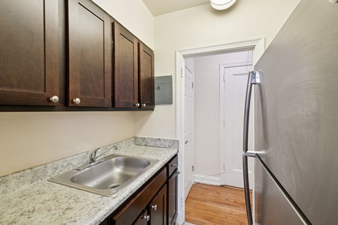 A kitchen with a sink and a refrigerator.