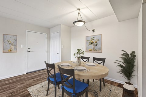 A dining room with a round table and chairs.