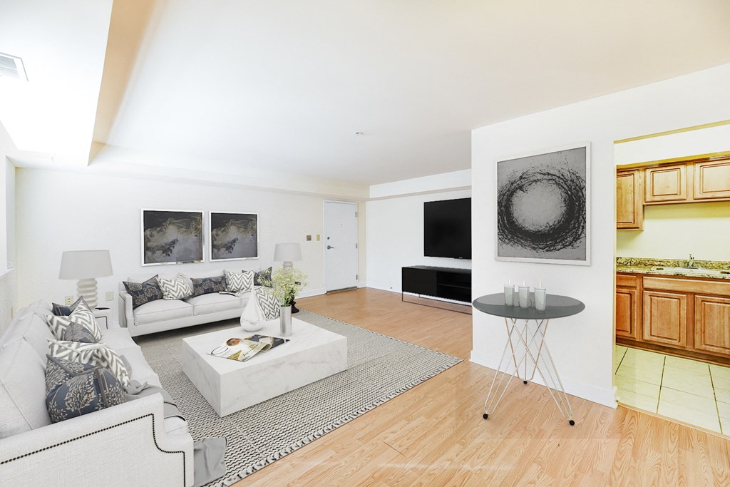 living area with sofa, coffee table, view of kitchen, tv, and hardwood flooring at jasper place apartments in washington dc