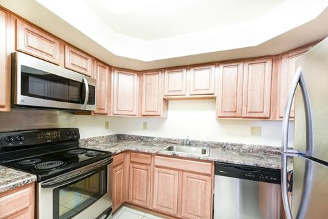 kitchen with stainless steel appliances and wood cabinetry at jasper place apartments in congress heights washington dc