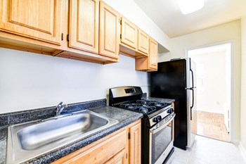 kitchen with wood cabinetry, tile flooring and window at the richman apartments in washington dc - Photo Gallery 3