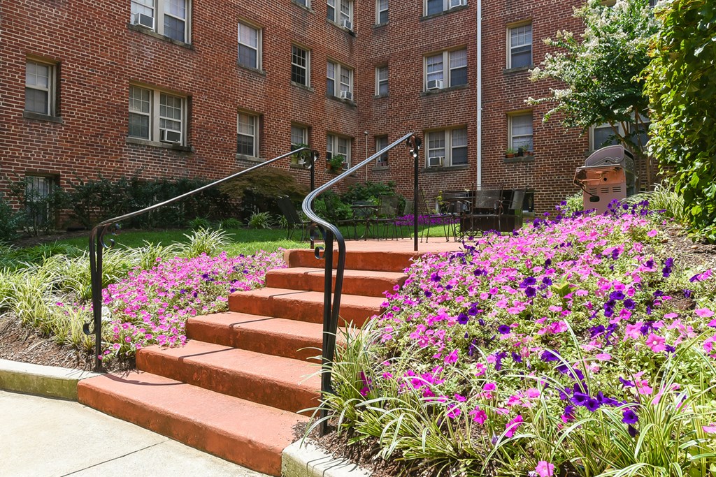 courtyard with table, chairs, grilling area and lush landscaping at meridian park apartments in washington dc