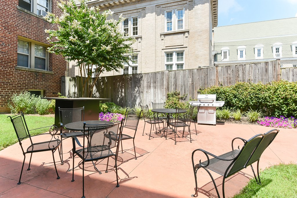 courtyard with table, chairs, grilling area and lush landscaping at meridian park apartments in washington dc