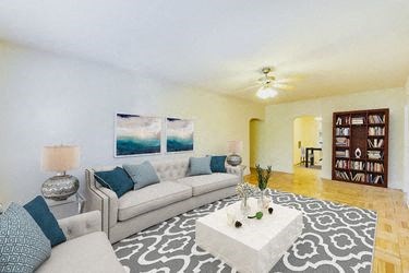 living area with seating area, coffee table, bookshelf, hardwood flooring and ceiling fan at meridian park apartments in washington dc
